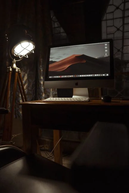 Dual monitors on a desk, showcasing web design in a modern office setting.